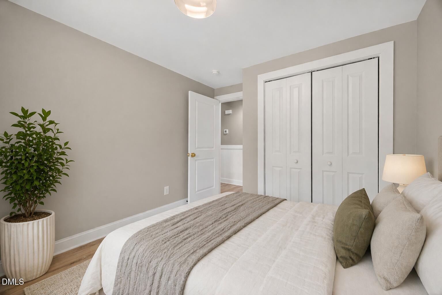 313 Crown Oaks Drive Raleigh, NC 27615 - Photo 21 of 60 a bedroom with a bed and a potted plant