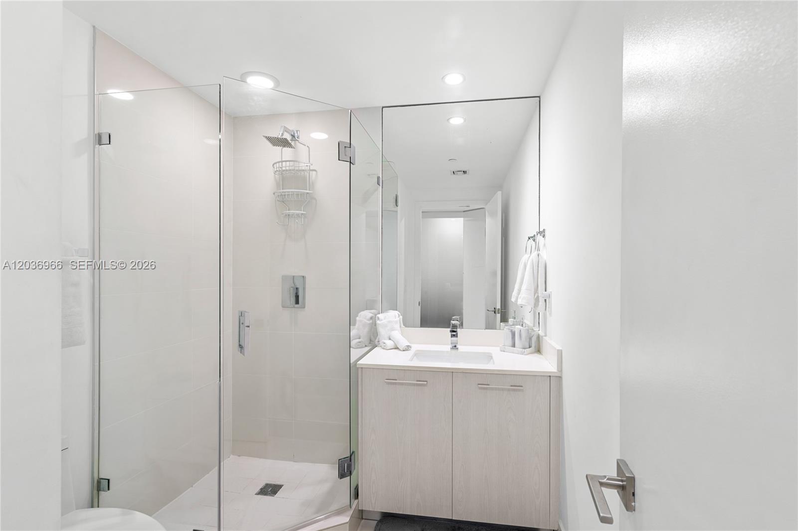 55 Southwest 9th Street, Unit 1904 Miami, FL 33130 - Photo 17 of 66 a bathroom with a shower sink and mirror