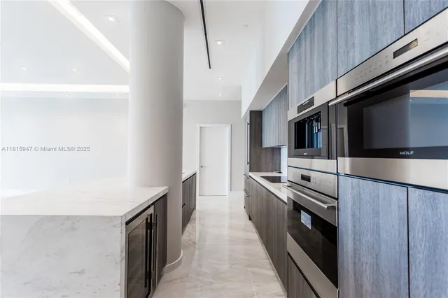a kitchen with stainless steel appliances a stove microwave and sink