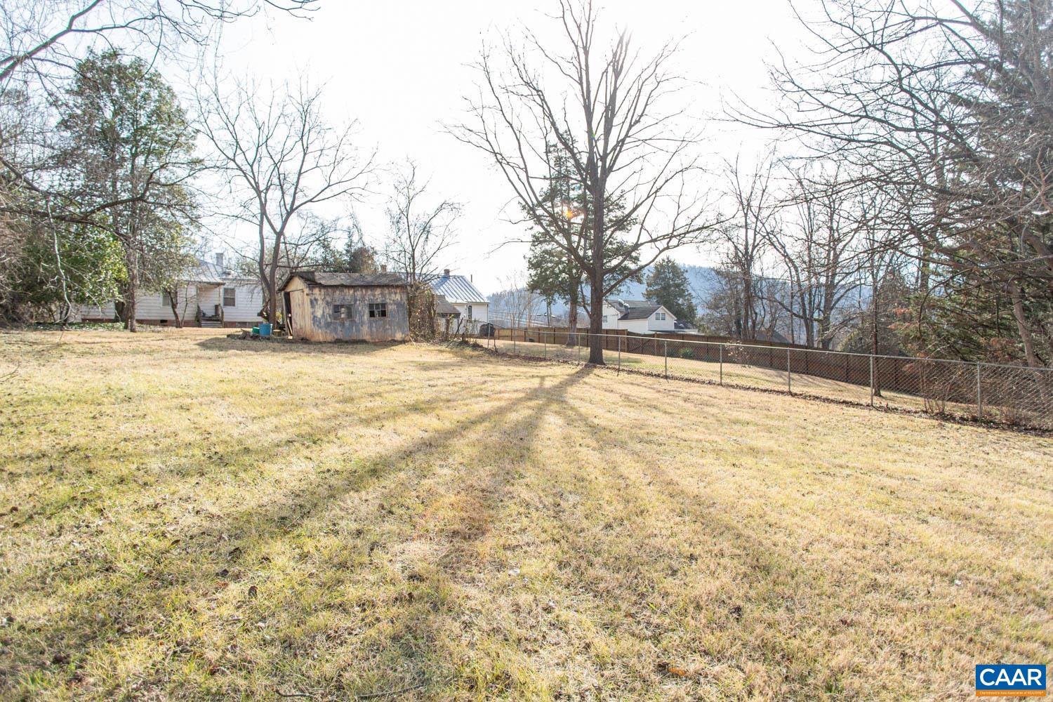 a view of yard with trees in the background