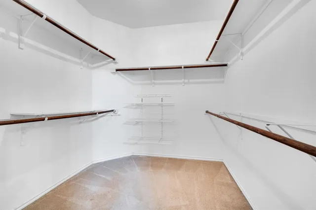 a view of walk in closet with empty racks