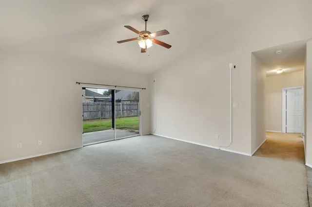 a view of an empty room with a ceiling fan