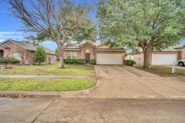 a view of a white house with a big yard and large trees