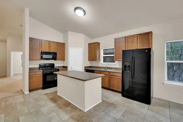 a kitchen with stainless steel appliances granite countertop a sink and a stove