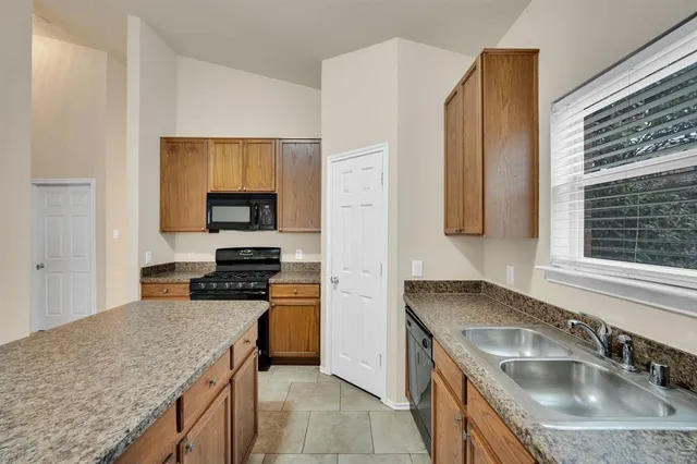 a kitchen with granite countertop stainless steel appliances and refrigerator