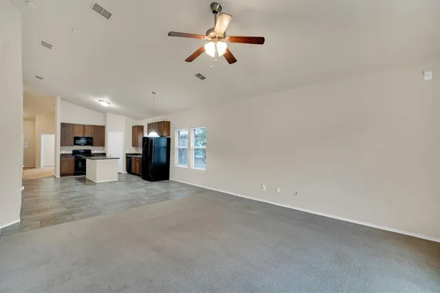 a view of a room with a ceiling fan and a window
