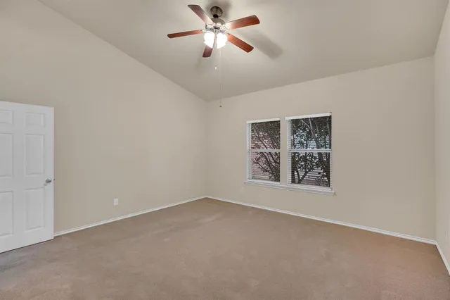 a view of an empty room with a ceiling fan