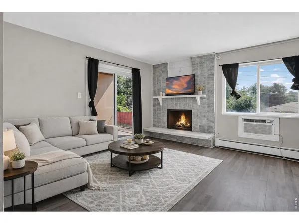 a living room with furniture large window and a fireplace