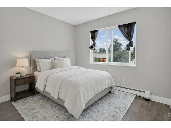 a bedroom with a bed and a painting on the wall