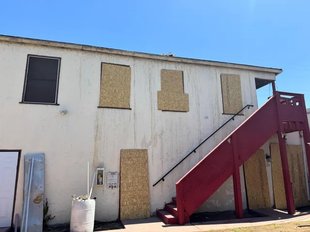 a side view of a house with a wooden fence