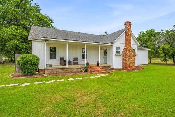 a view of a house with backyard and sitting area