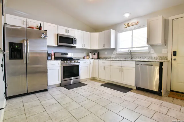 a kitchen with stainless steel appliances granite countertop a stove a sink and a refrigerator
