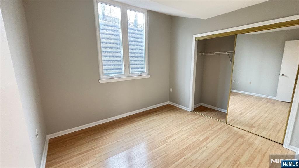 308-310 Passaic Avenue, Unit 201 Harrison, NJ 07029 - Photo 14 of 31 an empty room with wooden floor and windows