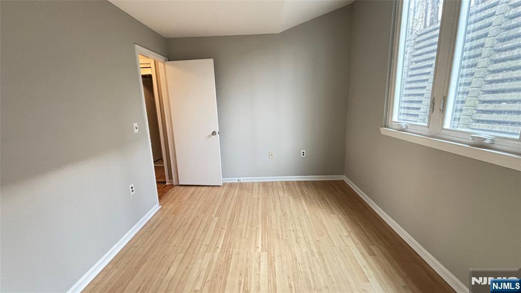 308-310 Passaic Avenue, Unit 201 Harrison, NJ 07029 - Photo 16 of 31 an empty room with wooden floor and windows