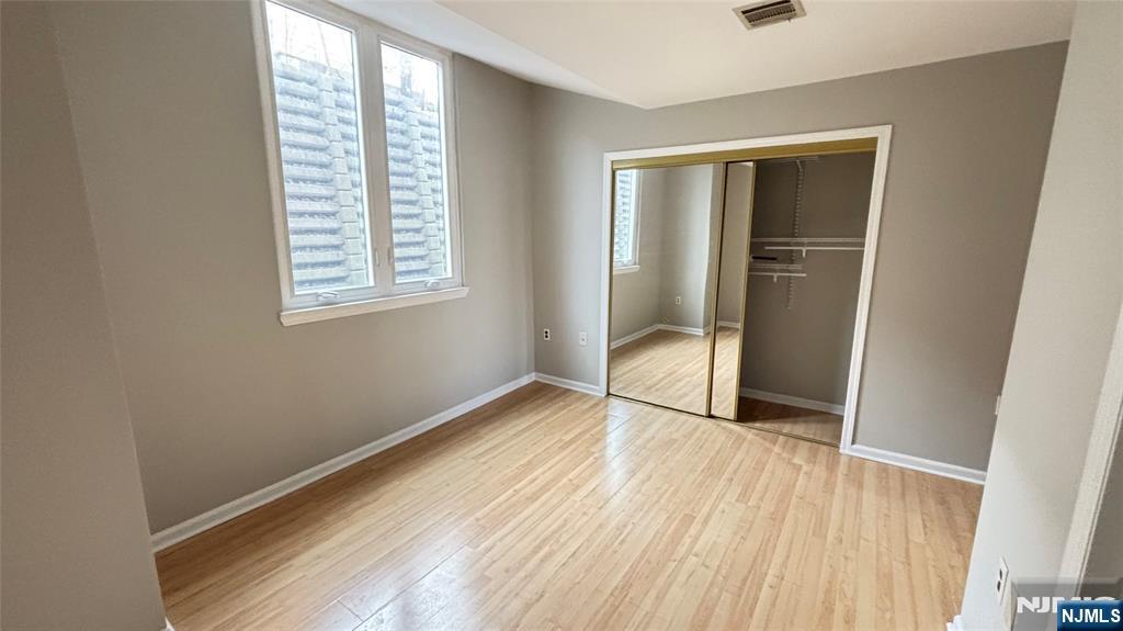 308-310 Passaic Avenue, Unit 201 Harrison, NJ 07029 - Photo 5 of 31 a view of an empty room with wooden floor and a window