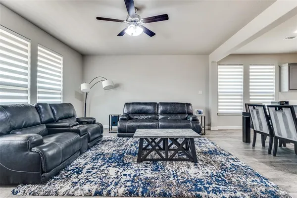 a living room with furniture a large window and a chandelier