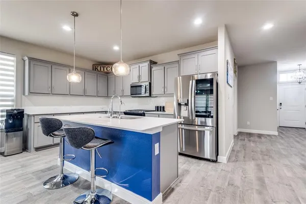 a kitchen with kitchen island a sink stove and refrigerator