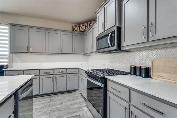 a kitchen with stainless steel appliances granite countertop a sink stove and cabinets