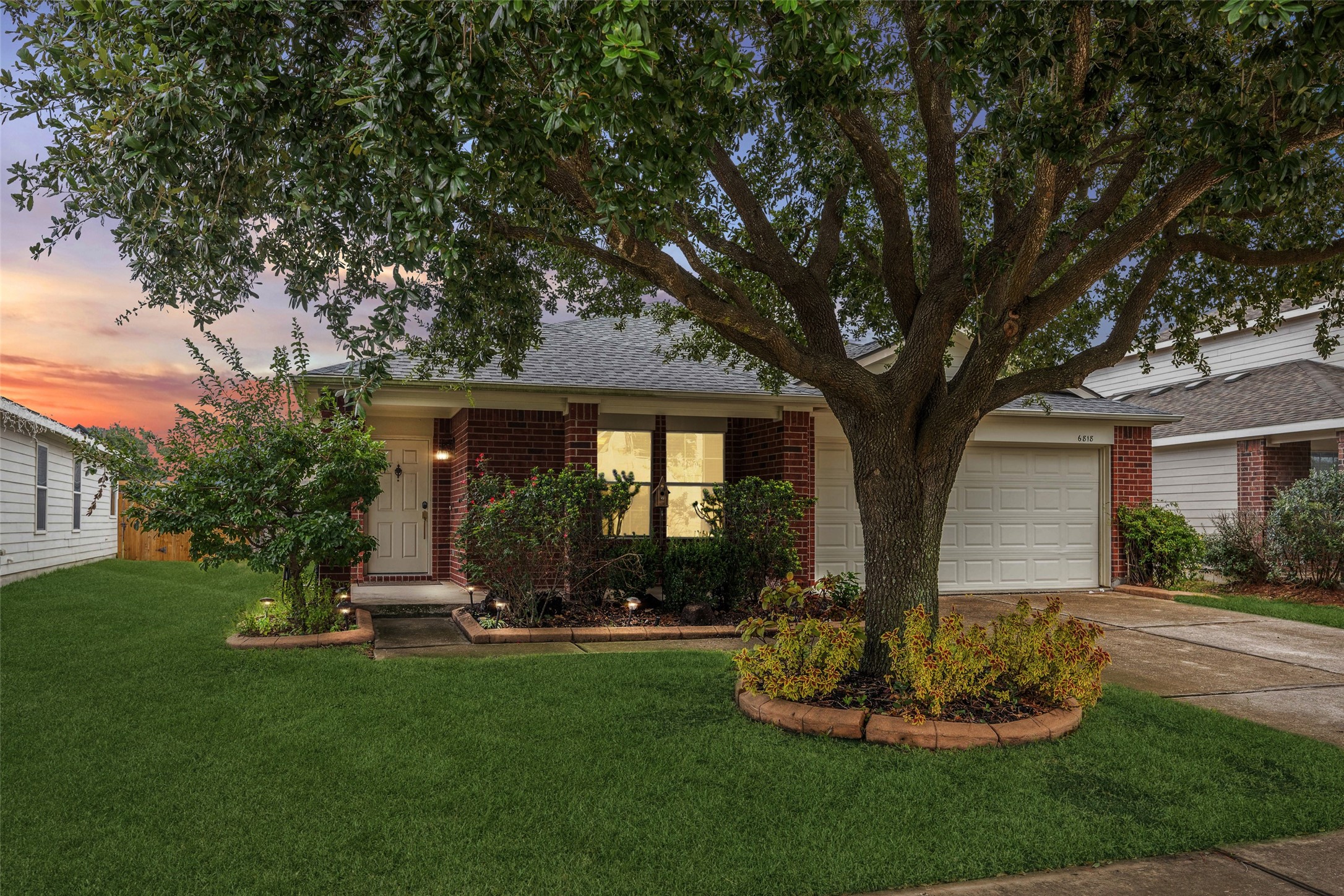 a front view of a house with a yard and tree