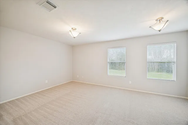 an empty room with a window and a ceiling fan