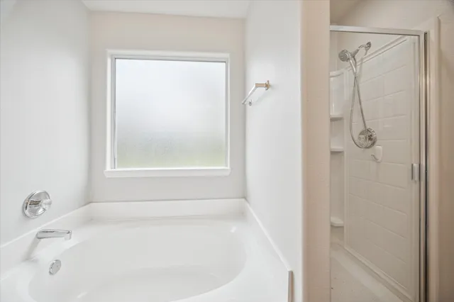 a white bath tub sitting next to a shower