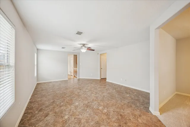 an empty room with a ceiling fan and a window