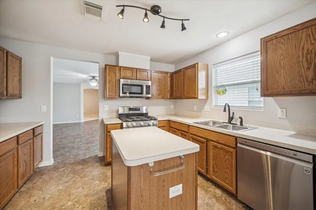 a kitchen with a sink a stove a refrigerator cabinets and a window