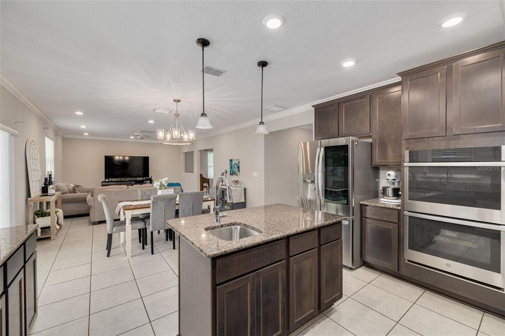 7242 Landmark Drive Spring Hill, FL 34606 - Photo 14 of 45 a kitchen with stainless steel appliances kitchen island granite countertop a sink and microwave