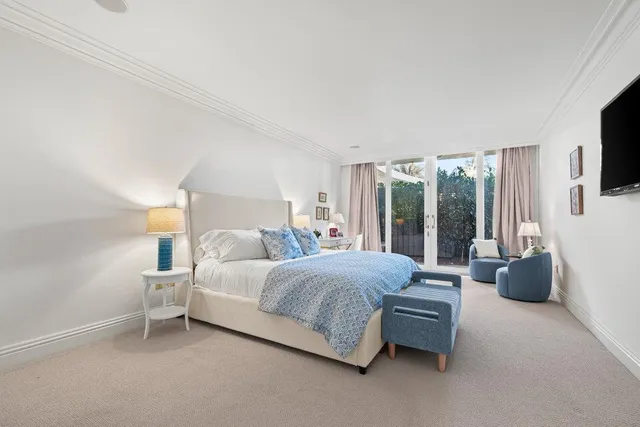 a bedroom with a bed and large window