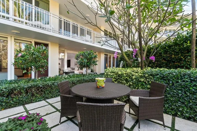 a view of a patio with a table and chairs and potted plants