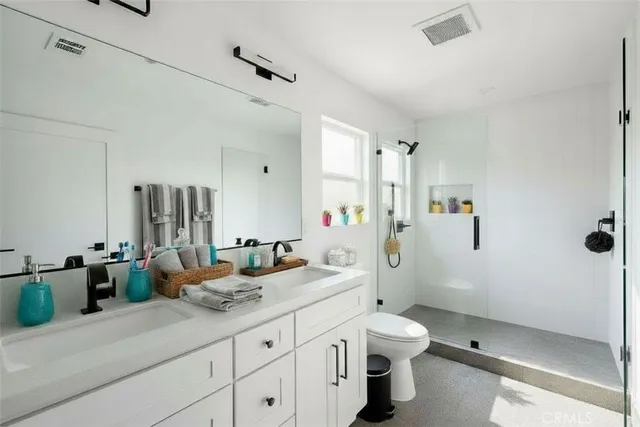 a bathroom with a double vanity sink toilet and shower