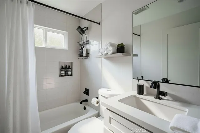 a bathroom with a granite countertop sink a mirror a bathtub and shower
