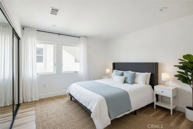 a bedroom with a bed and a potted plant