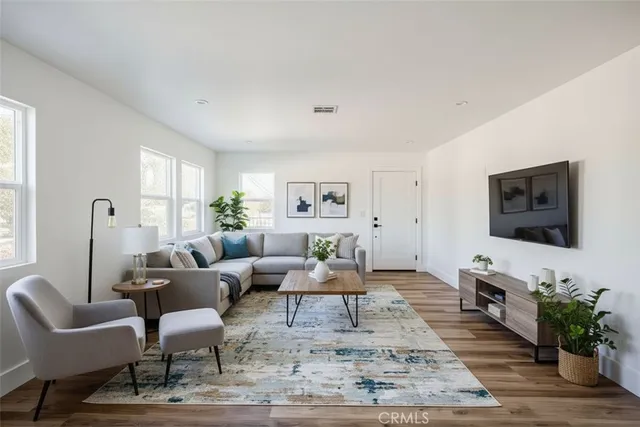 a living room with furniture flat screen tv and window