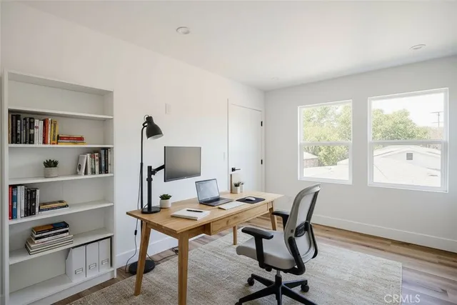 a view of a workspace with furniture and a window