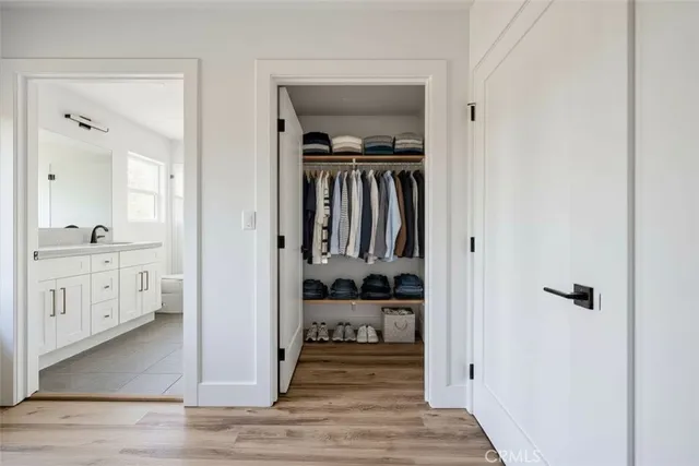a view of a hallway with wooden floor windows and a bathroom