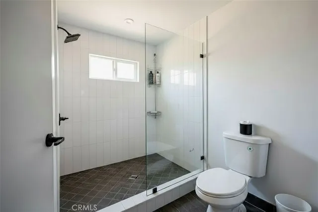 a bathroom with a granite countertop toilet a sink and shower