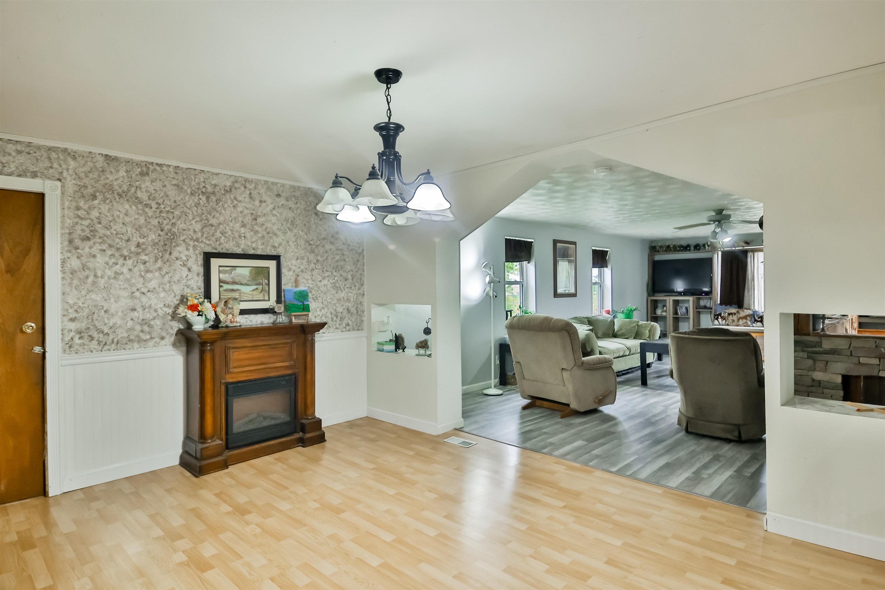 7719 West Coffman Road German Valley, IL 61039 - Photo 23 of 38 a living room with furniture a chandelier and a fireplace