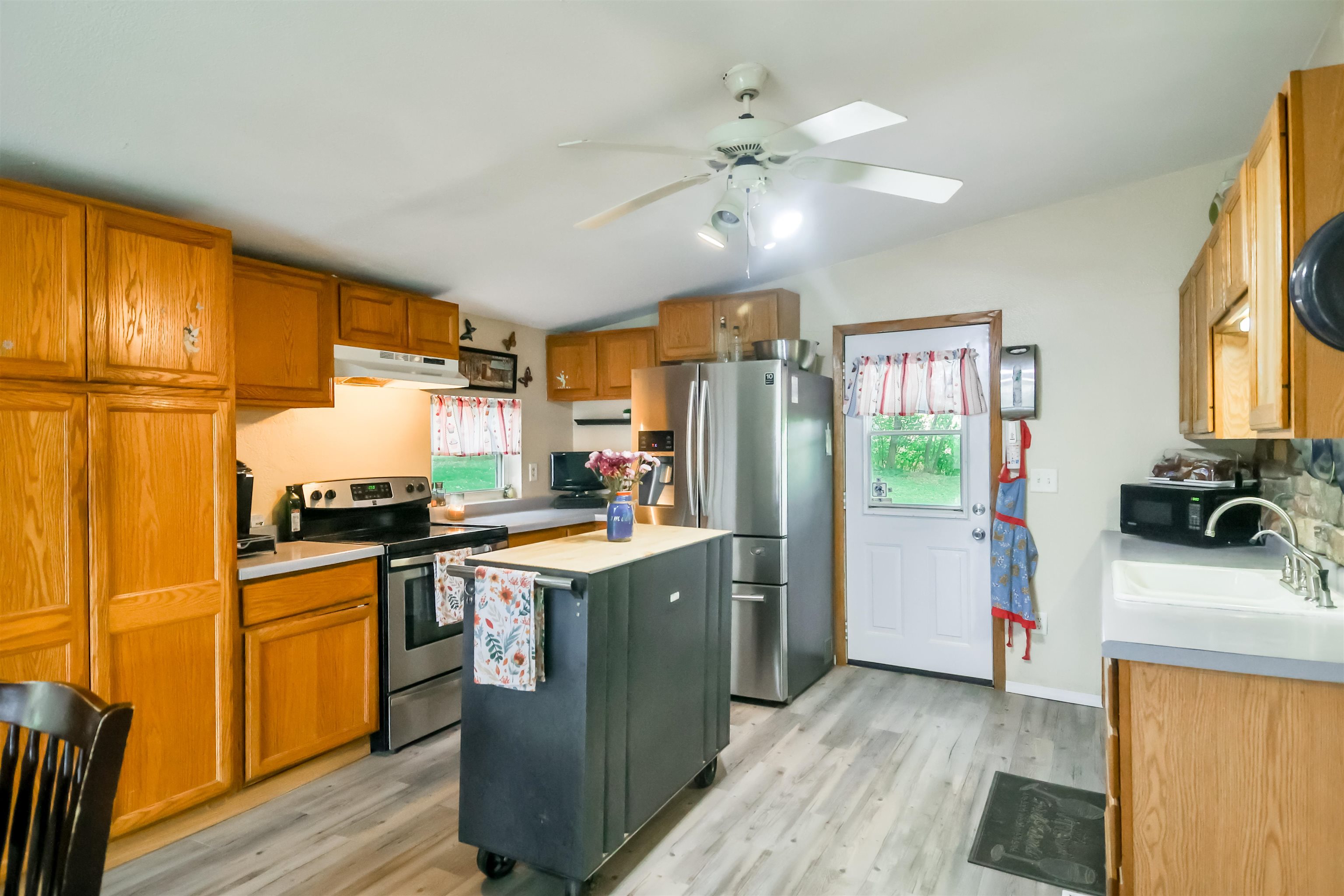 7719 West Coffman Road German Valley, IL 61039 - Photo 25 of 38 a kitchen with stainless steel appliances granite countertop a stove top oven a refrigerator a sink dishwasher with a dining table and chairs
