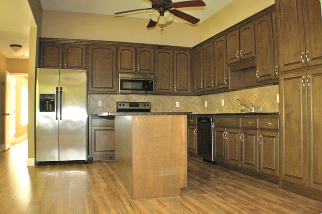 23 Isbell Road Fort Mitchell, AL 36856 - Photo 12 of 37 a kitchen with stainless steel appliances granite countertop a refrigerator a sink and white cabinets with wooden floor