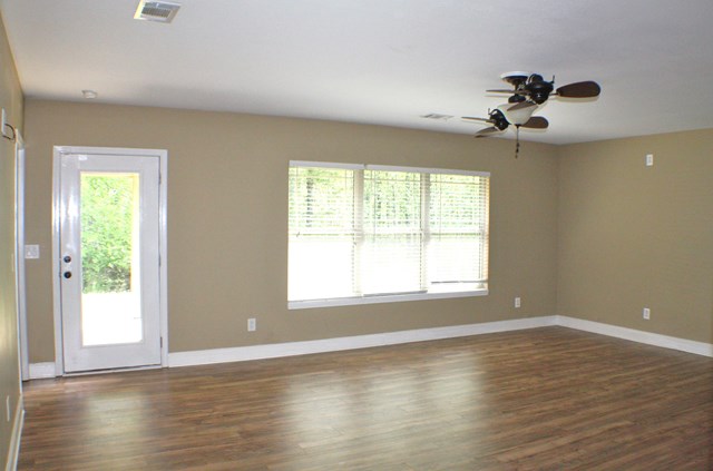 23 Isbell Road Fort Mitchell, AL 36856 - Photo 18 of 37 an empty room with wooden floor chandelier fan and windows