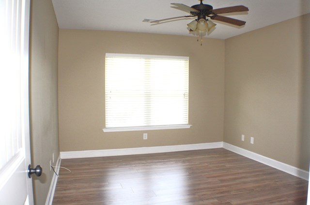 23 Isbell Road Fort Mitchell, AL 36856 - Photo 33 of 37 an empty room with wooden floor a ceiling fan and windows