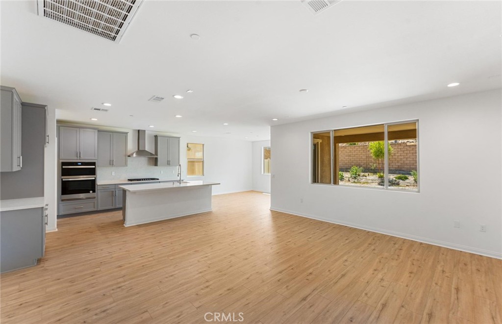 26615 Silver Ore Road Menifee, CA 92570 - Photo 2 of 30 a large kitchen with stainless steel appliances kitchen island a large counter top and a wooden floors