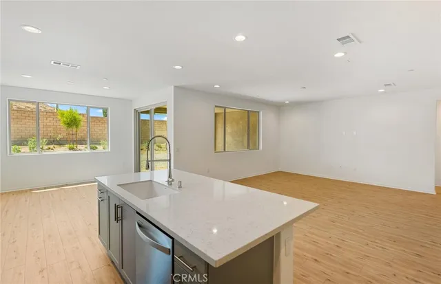 a kitchen with a sink cabinets and wooden floor