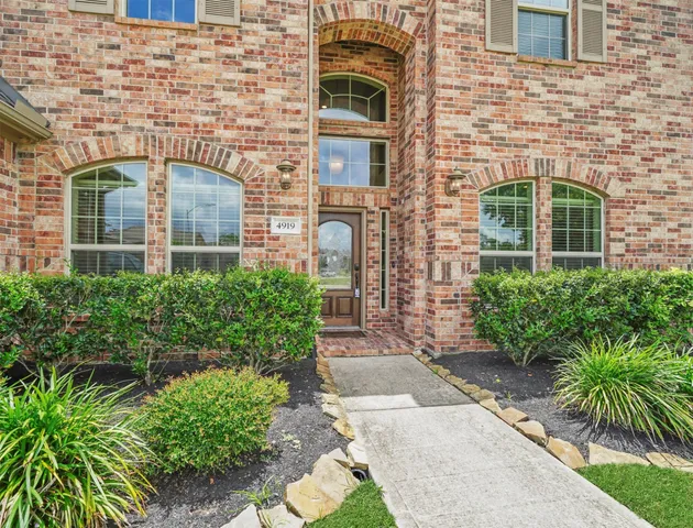 front view of a brick house with a yard