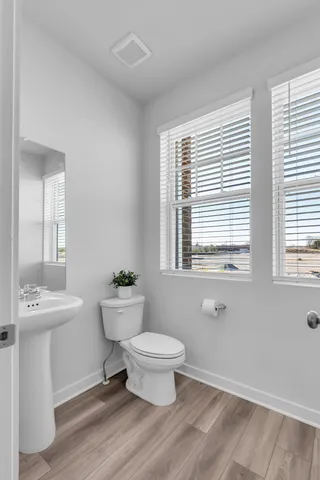 a bathroom with a toilet a sink and a window