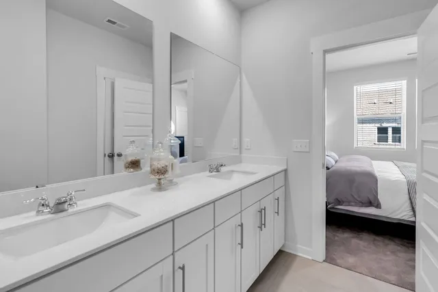 a en suite bathroom with double sink and a large mirror