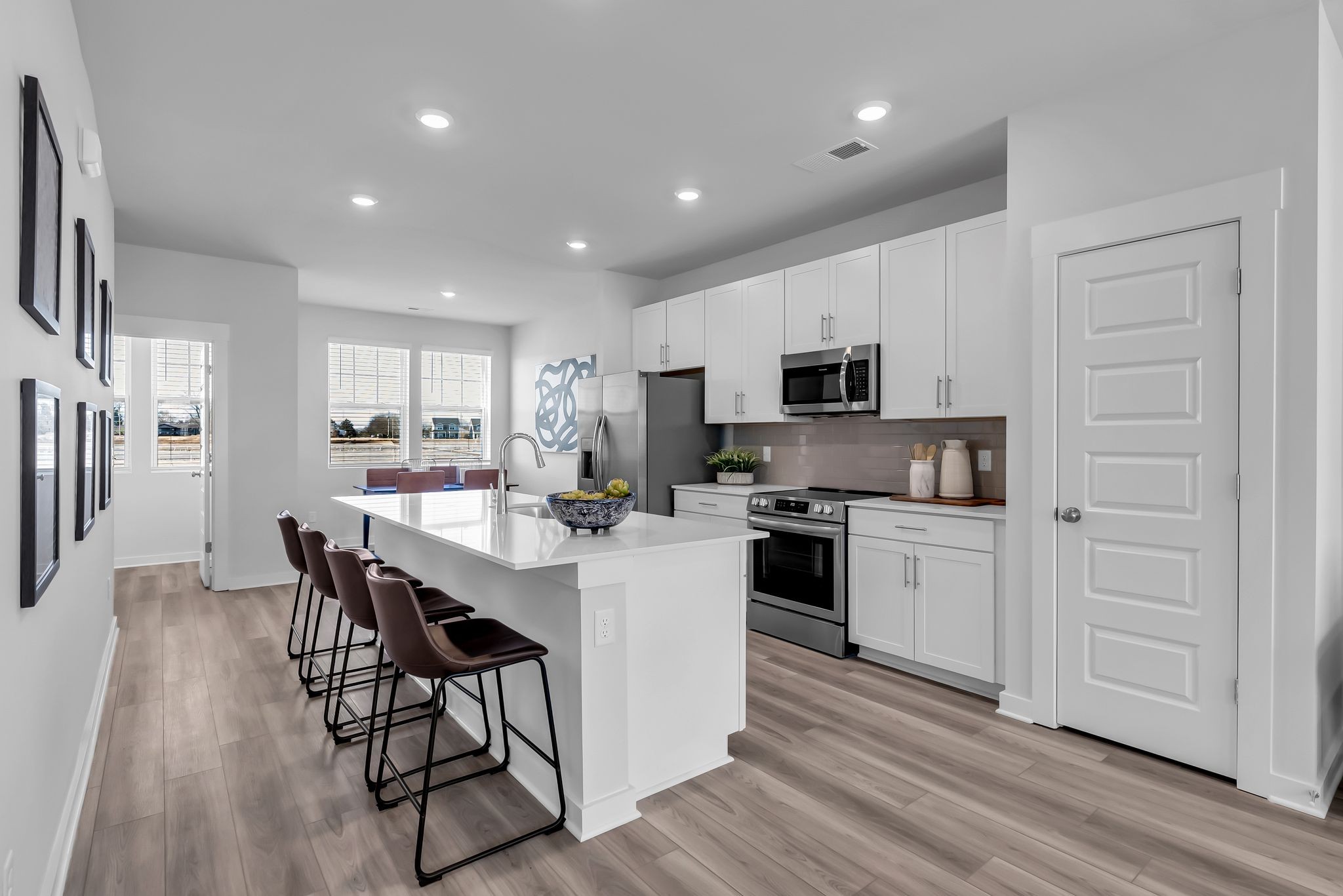 516 Hinton Street Lebanon, TN 37090 - Photo 8 of 24 a kitchen with microwave a stove top oven a refrigerator a dining table and chairs with wooden floor