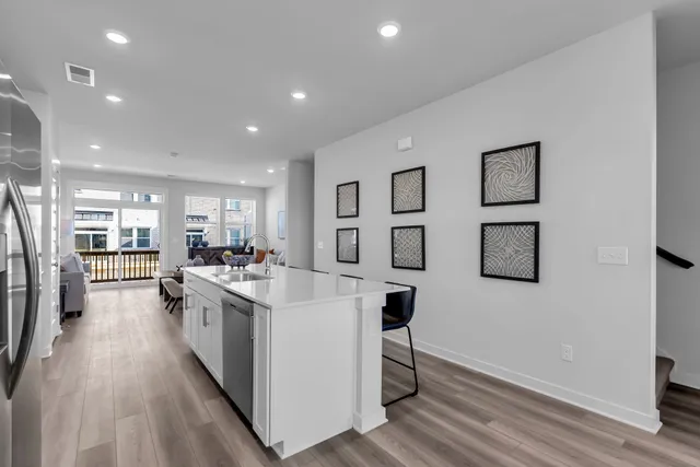 a kitchen with stainless steel appliances a stove a refrigerator a dining table and chairs