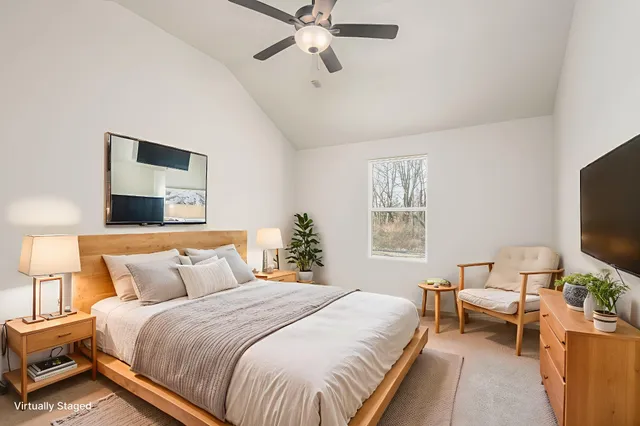 a spacious bedroom with a bed and a flat screen tv